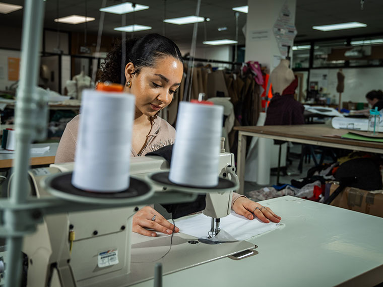 A fashion student using a sewing machine
