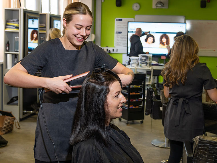 A hairdressing student working on a client