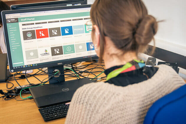 A member of staff sat at a computer