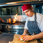 A student preparing a burget in The Wharncliffe Restaurant kitchen