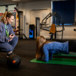 A student being timed doing a plank in the gym