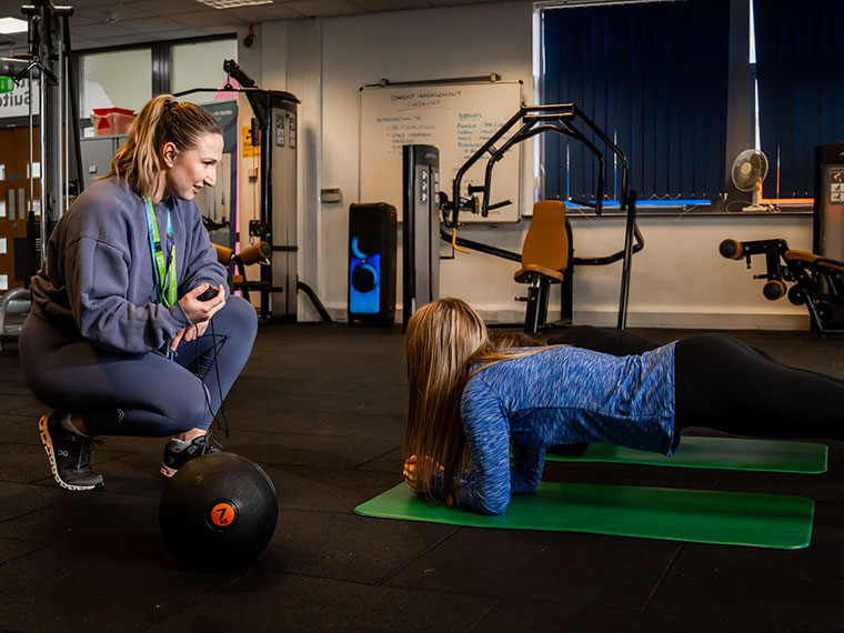 A student being timed doing a plank in the gym