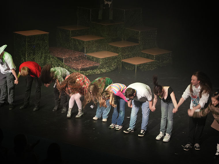 Students taking a bow on stage after a performance