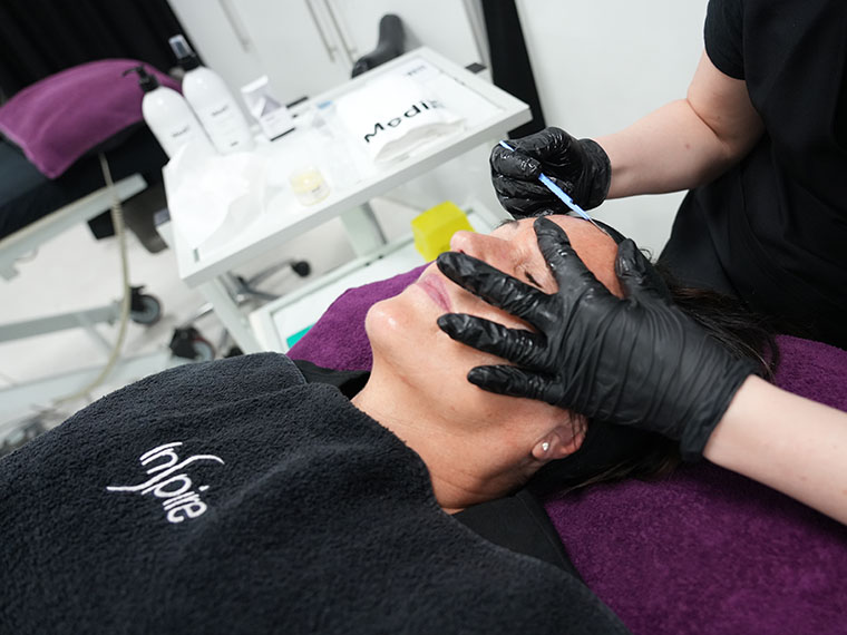 A student giving a client a beauty treatment