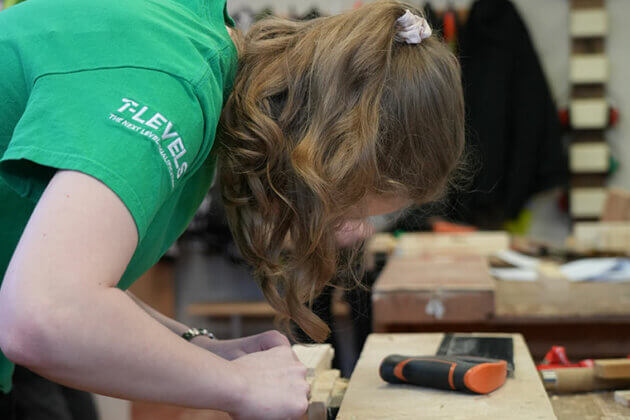 A joinery student working at a bench