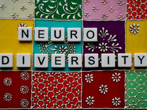 Letters spelling our neurodiversity on a colourful patchwork background